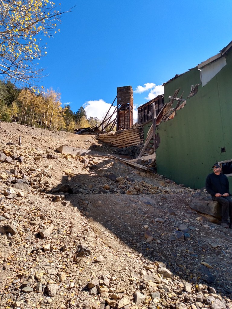 View from below looking up at the outside of the stamp mill and the large wooden tower above the mine.