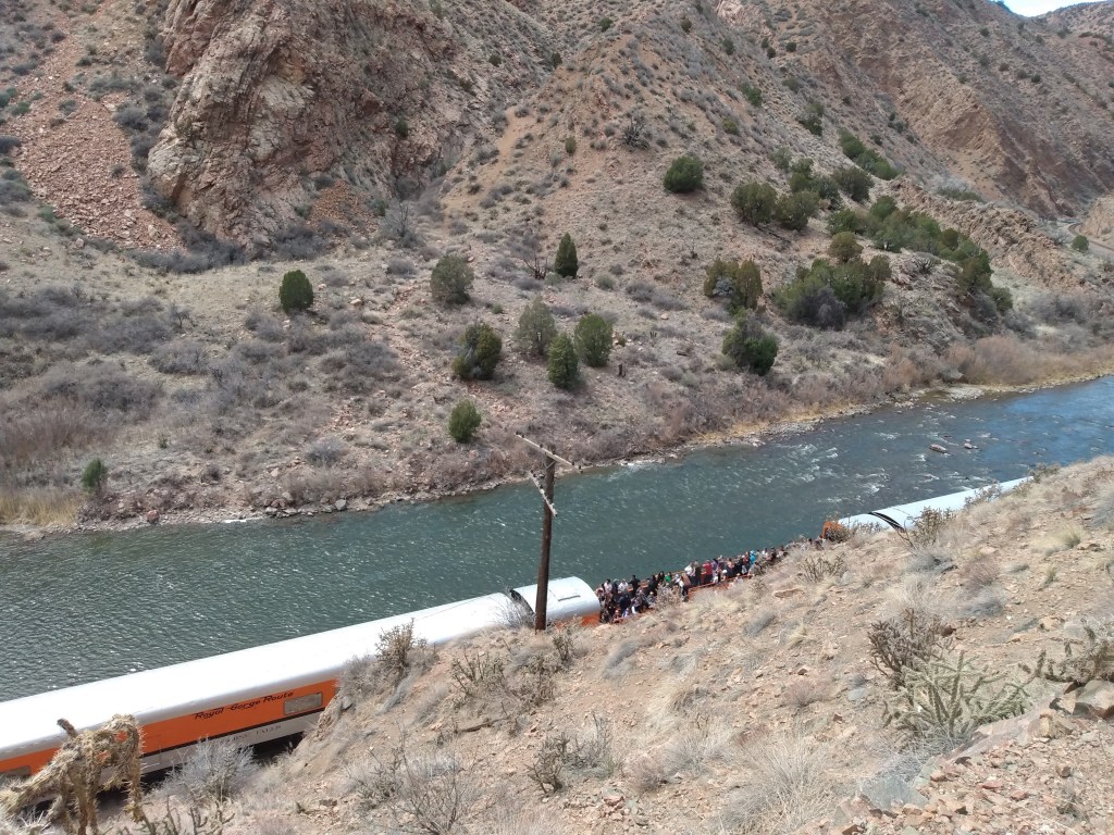 Photo looking down on train running along river