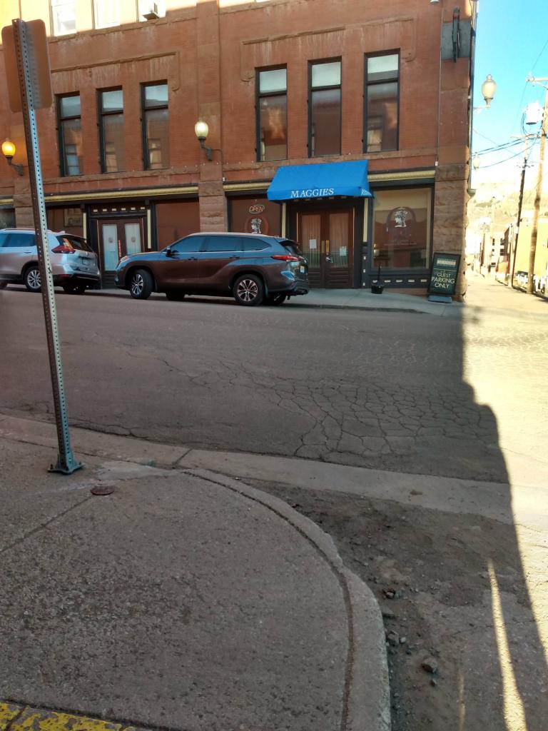 Building with wood and glass doors and an awning proclaiming "Maggie's Place".