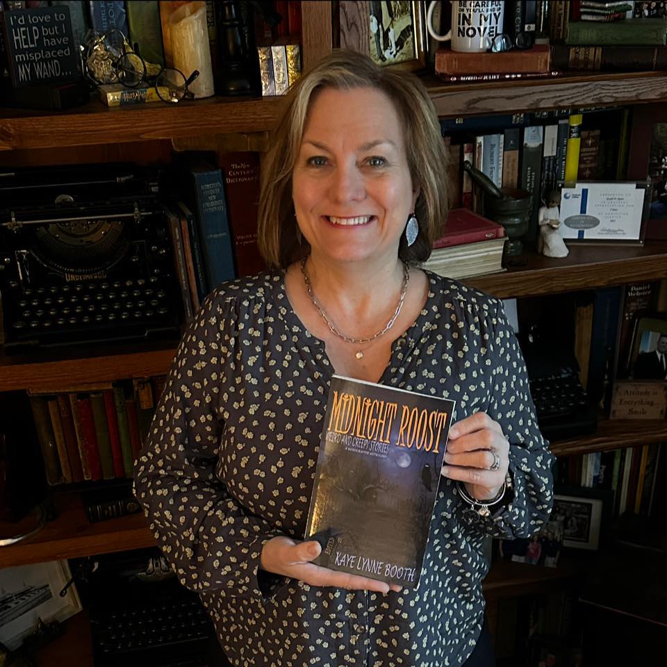 Author Denise Aparo holding a copy of Midnight Roost