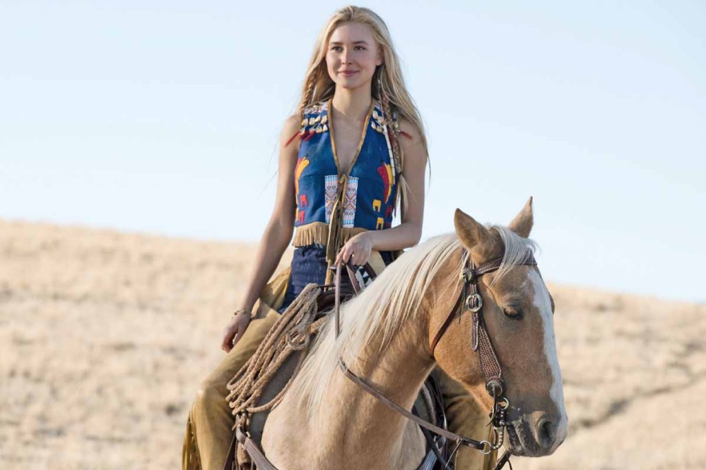 Young woman on horseback dressed in native American attire.