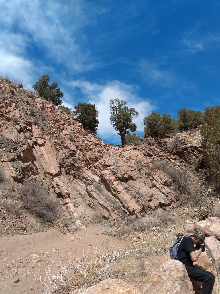 Rock cliff rising up to blue sky