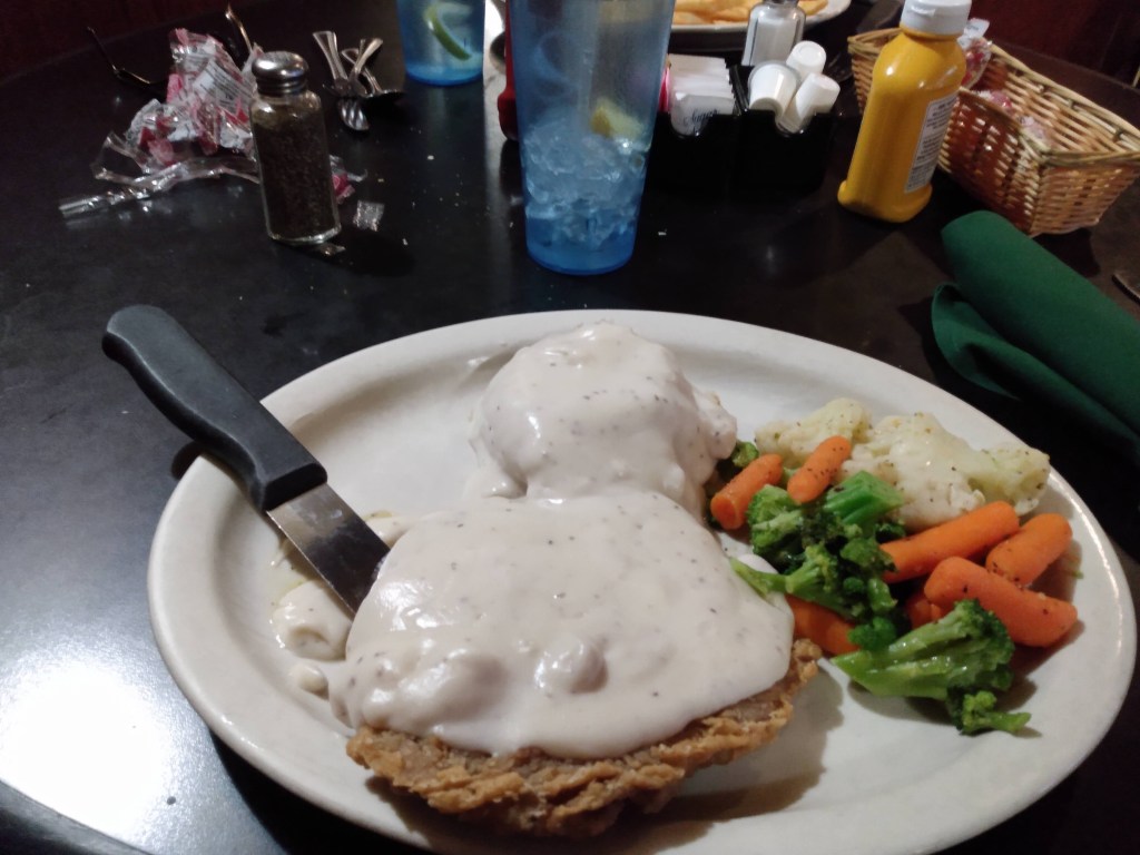 Orange carrots with broccoli & cauliflower on a plate with chicken friend steak, mashed potatoes & gravy