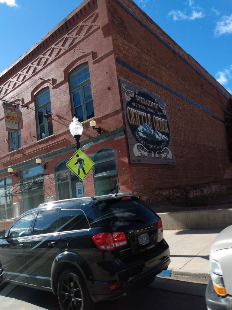 A large Cripple Creek sign painted on the side of a building