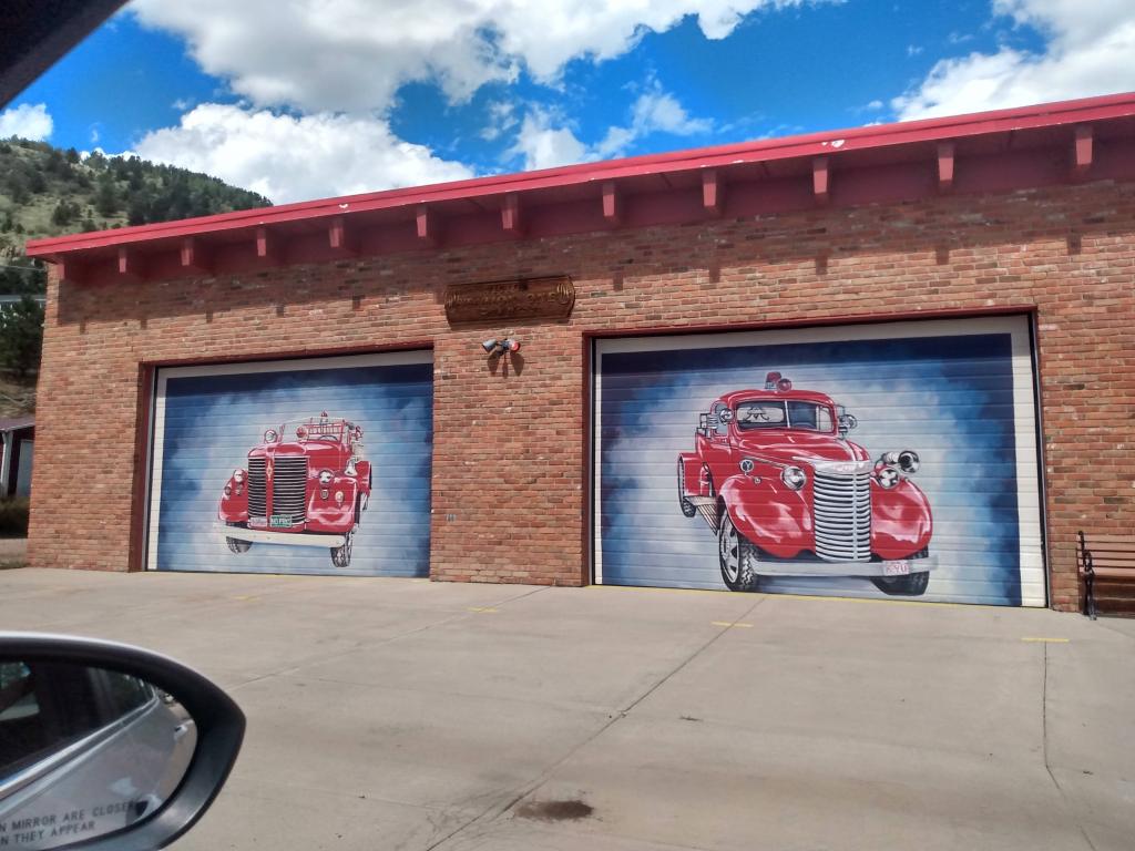 Two garage doors with painted firetrucks on them.